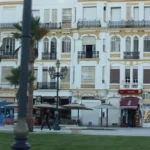 Building with Decorative Facade Building featuring a decorative facade with balconies and palm trees in front.